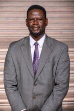 Portrait of Martin Okumu standing on the steps of the SF City Hall rotunda