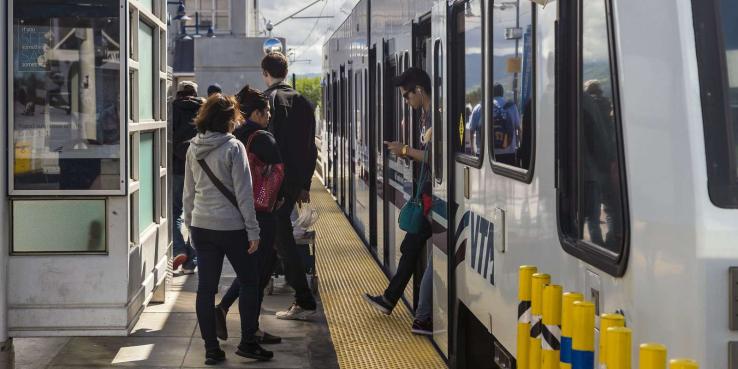 People entering and exiting a train.