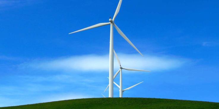 windmill on grassy hill on a sunny day