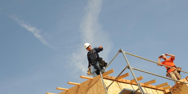 man walking across building under construction