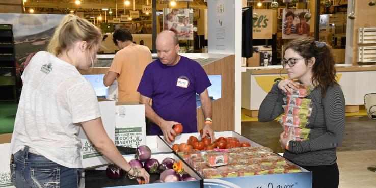 A group of 3 sorts through produce.