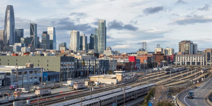 View of Caltrain railyard, SF, with skyline and bay bridge in baxkground