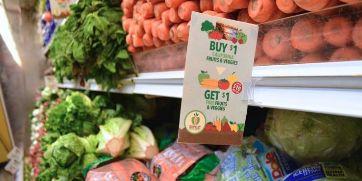 Image of vegetables in the grocery store with a double up food bucks sign