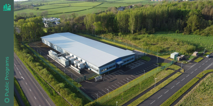 Image of large industrial building surrounded by greenery