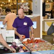 A group of 3 sorts through produce.