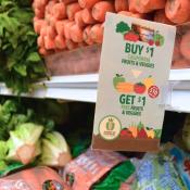 Image of vegetables in the grocery store with a double up food bucks sign