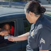 Man giving his drivers license to a police officer.