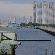 An image of two people swimming in Jakarta near a high-rise