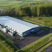Image of large industrial building surrounded by greenery