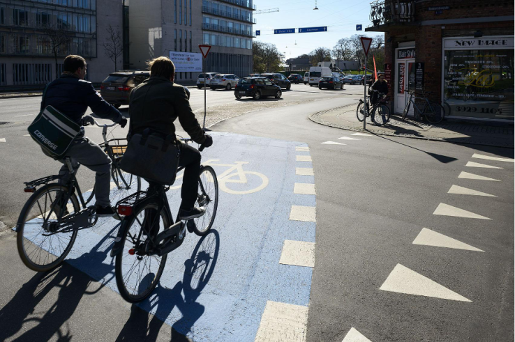 Curb-separated bicycle lanes are connected through intersections with clearly painted markings. 