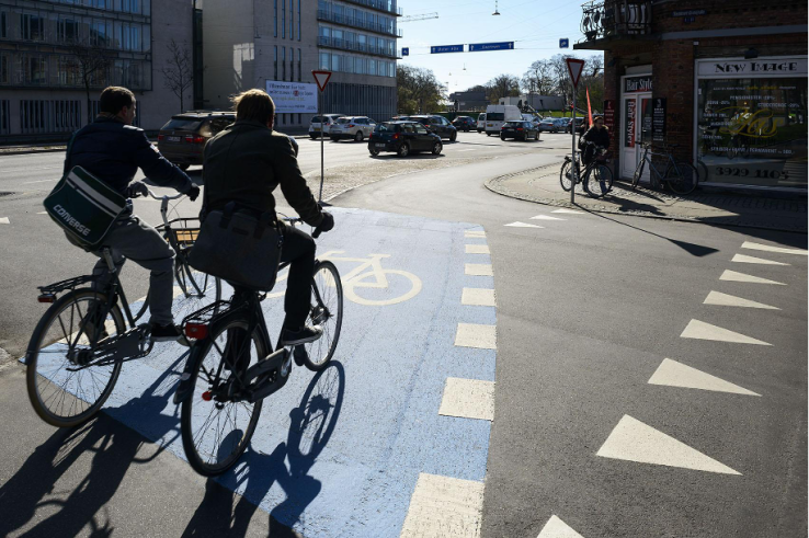 Curb-separated bicycle lanes are connected through intersections with clearly painted markings.