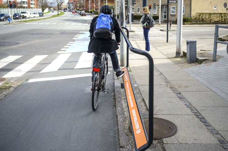 A convenient footrest helps a cyclist waiting at an intersection. 