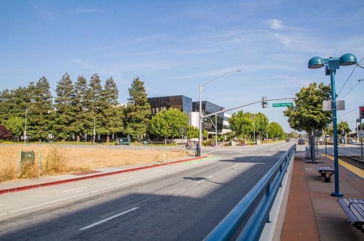 A road with a blue railing and a building