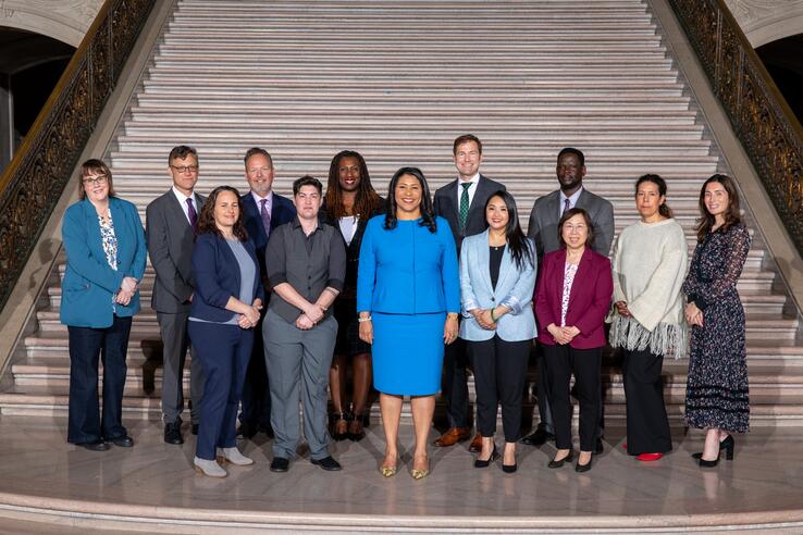 Award honorees standing on the steps of the San Francisco City Hall rotunda with Mayor Breed