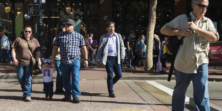 A family and two pedestrians walking down a San Francisco crosswalk