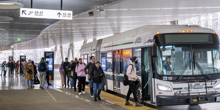 Riders boarding an AC Transit bus at the Transbay Transit Center