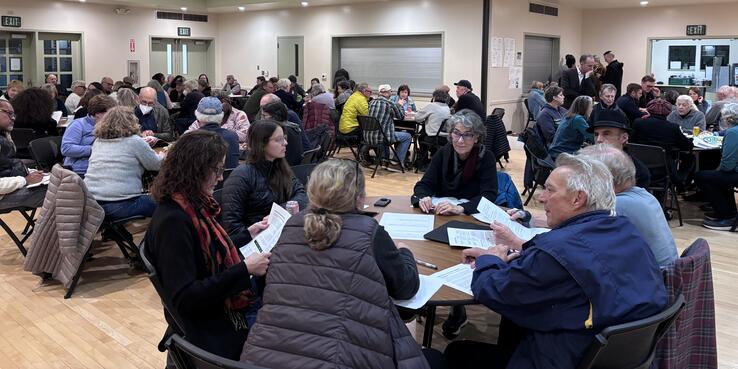 Oakland residents sitting at breakout tables during a community meeting