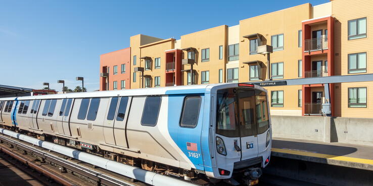 BART train pulling in next to apartment building at Fruitvale Station