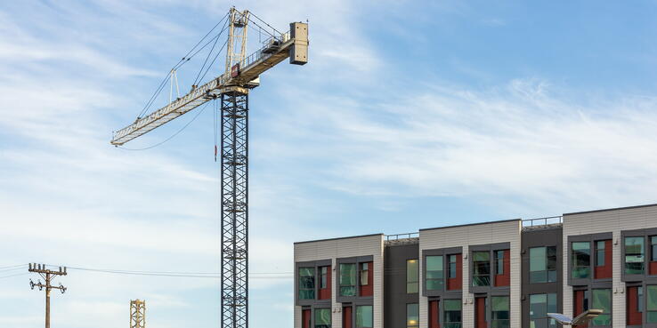 Photo of a construction crane next to a new apartment building