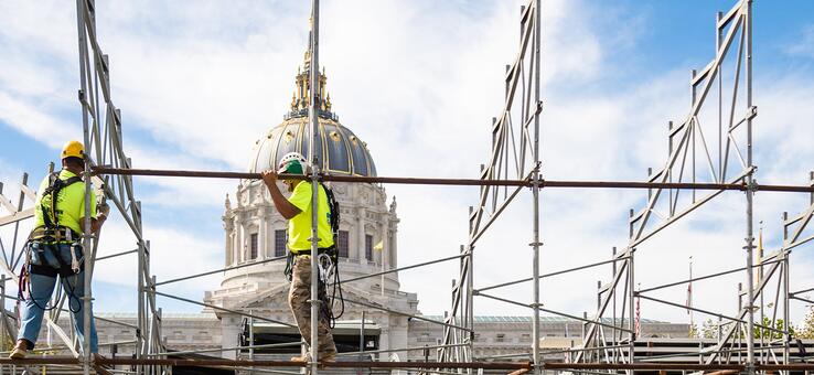 construction workers putting up scaffolding