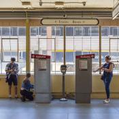 Amtrak California ticket machines in station with people waiting