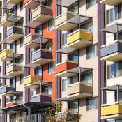 A colorful aparment building facade with numerous balconies