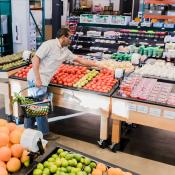 High Angle View Man Selecting Tomatoes in Grocery Store