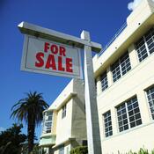 For sale sign outside art deco apartment building 