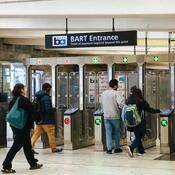 People walking through BART turnstiles